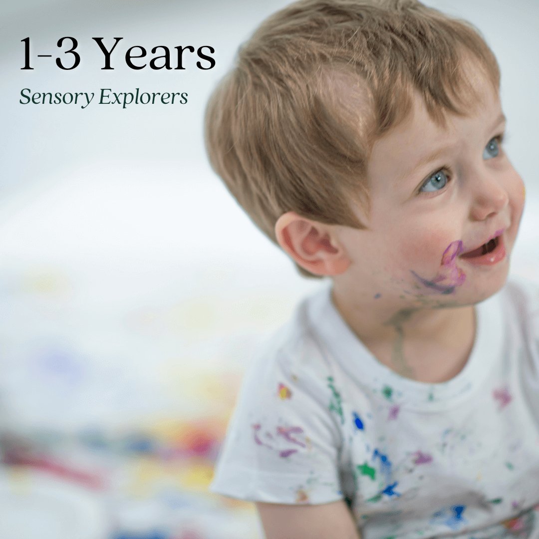 Smiling toddler with paint on face and shirt, engaging in sensory play. Text reads "1–3 Years, Sensory Explorers