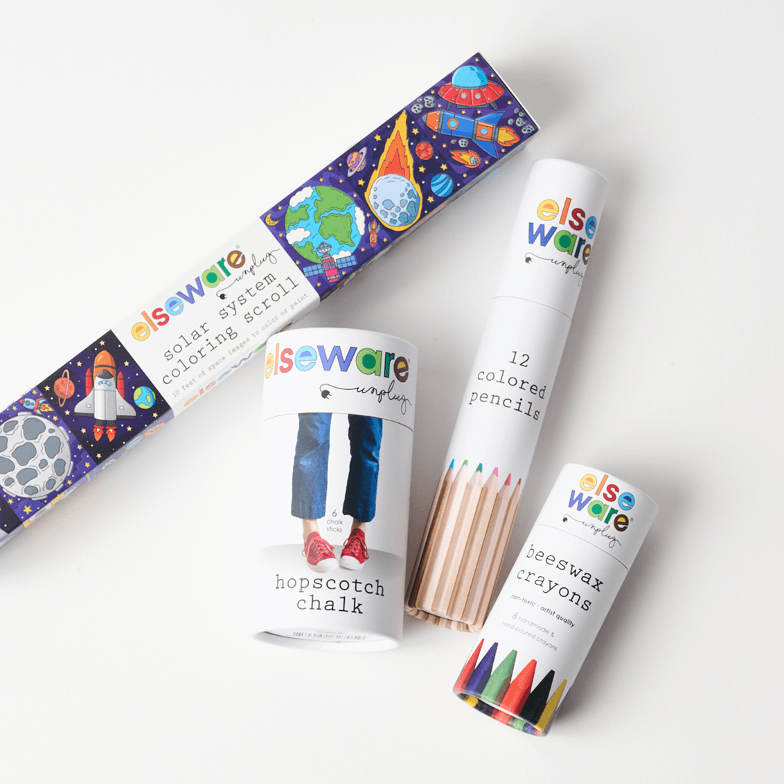 Set of Else Ware art supplies including coloring scroll, colored pencils, chalk, and crayons on a white background.