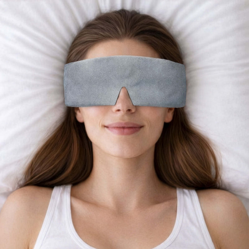 Woman wearing a gray sleep mask in bed