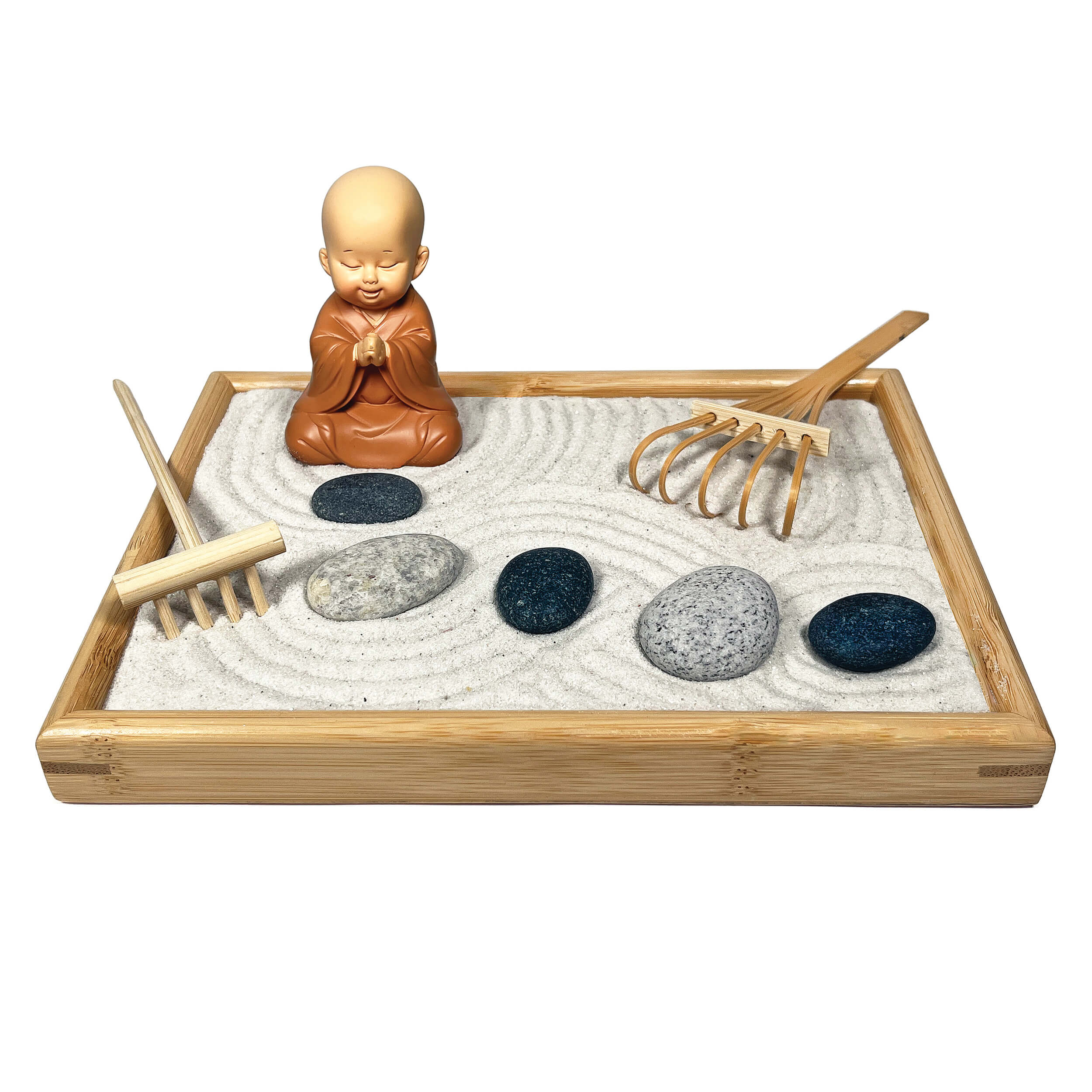 Zen garden with sand, stones, and a small monk figurine on a white background