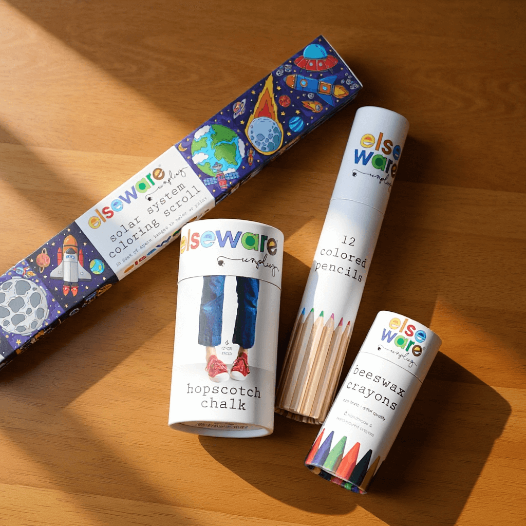 Set of educational and art supplies including coloring pencils, crayons, and chalk on a wooden surface.