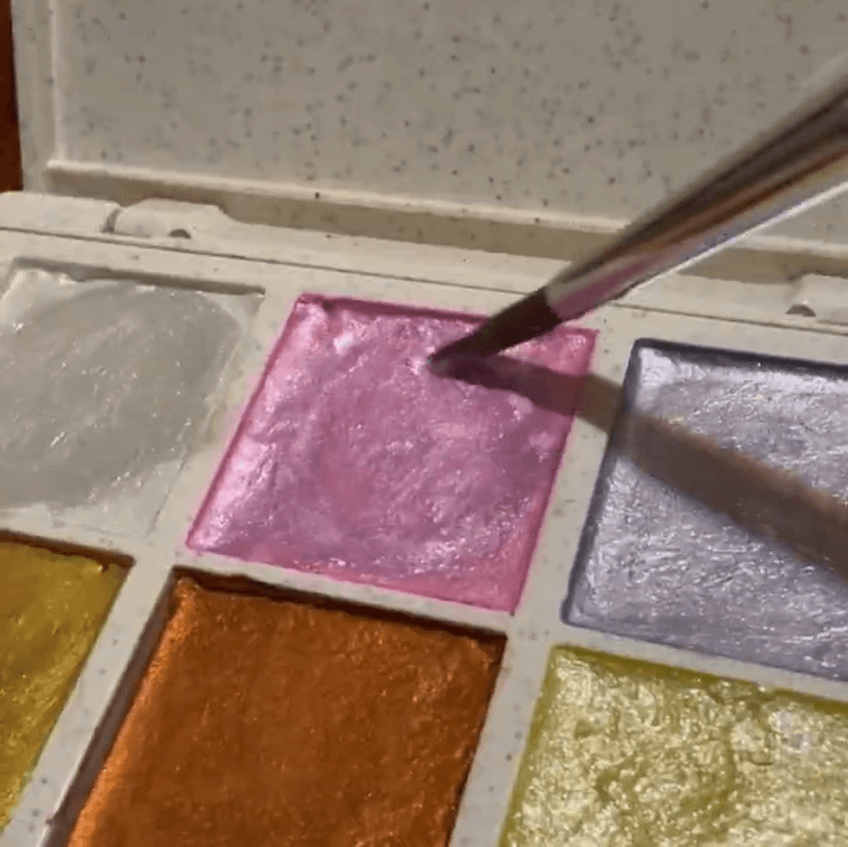 Artist painting seashells using Elseware Unplug metallic watercolors with a soft shimmer effect